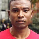Close-up portrait of a man outdoors in Greater London, showcasing confidence and style.